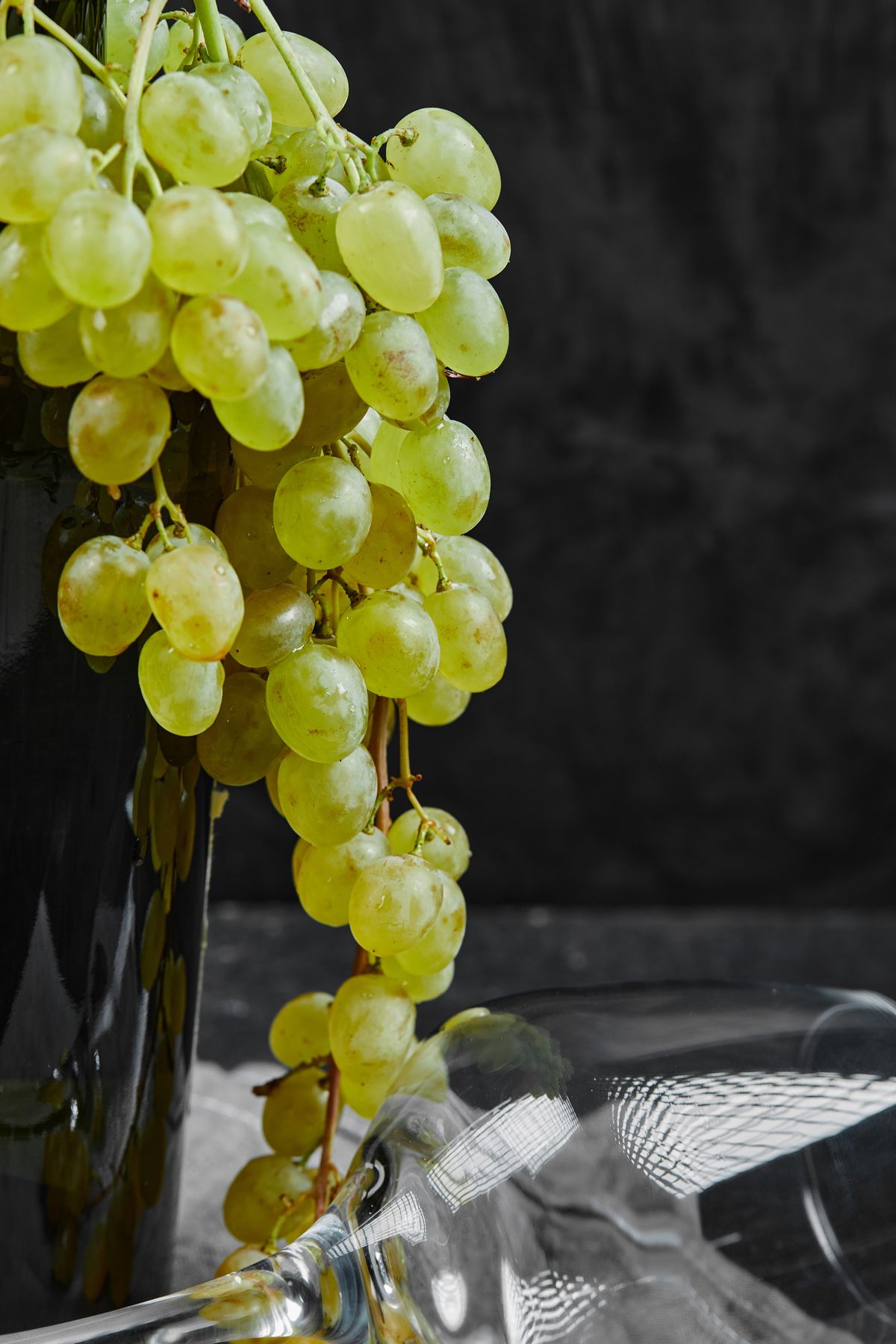 A bunch of green grapes on the bottle of wine
