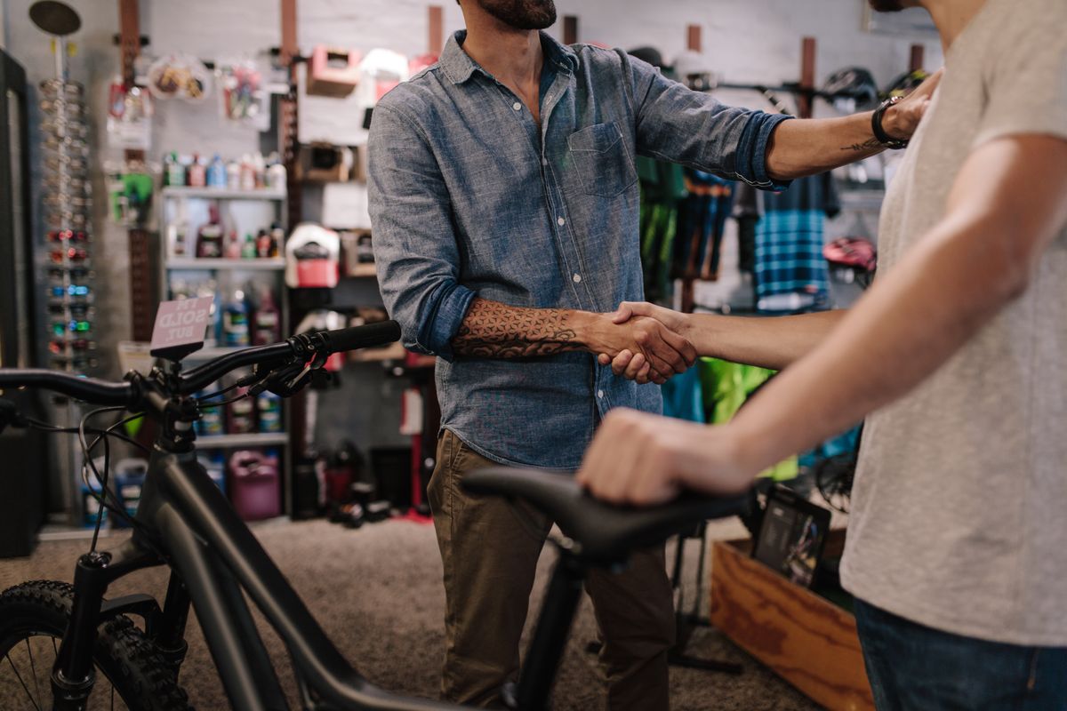 Cropped,Shot,Of,Shop,Owner,Giving,A,Handshake,To,A