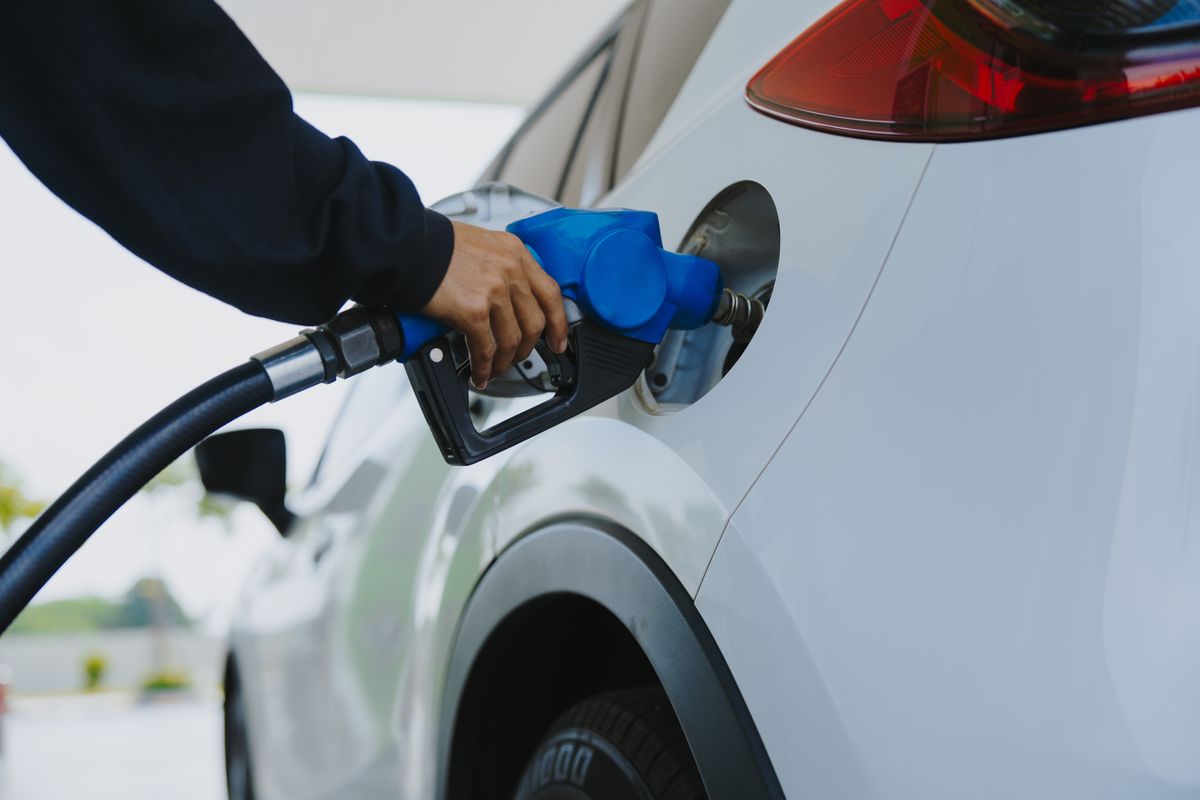 Close-up,Of,Gas,Station,Attendant's,Hand,With,Blue,Fuel,Nozzle.